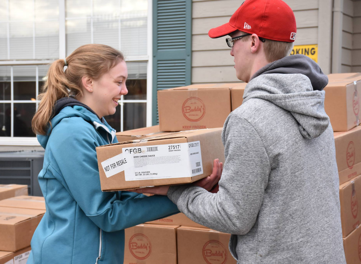 Photo of a women and a man carrying a box together