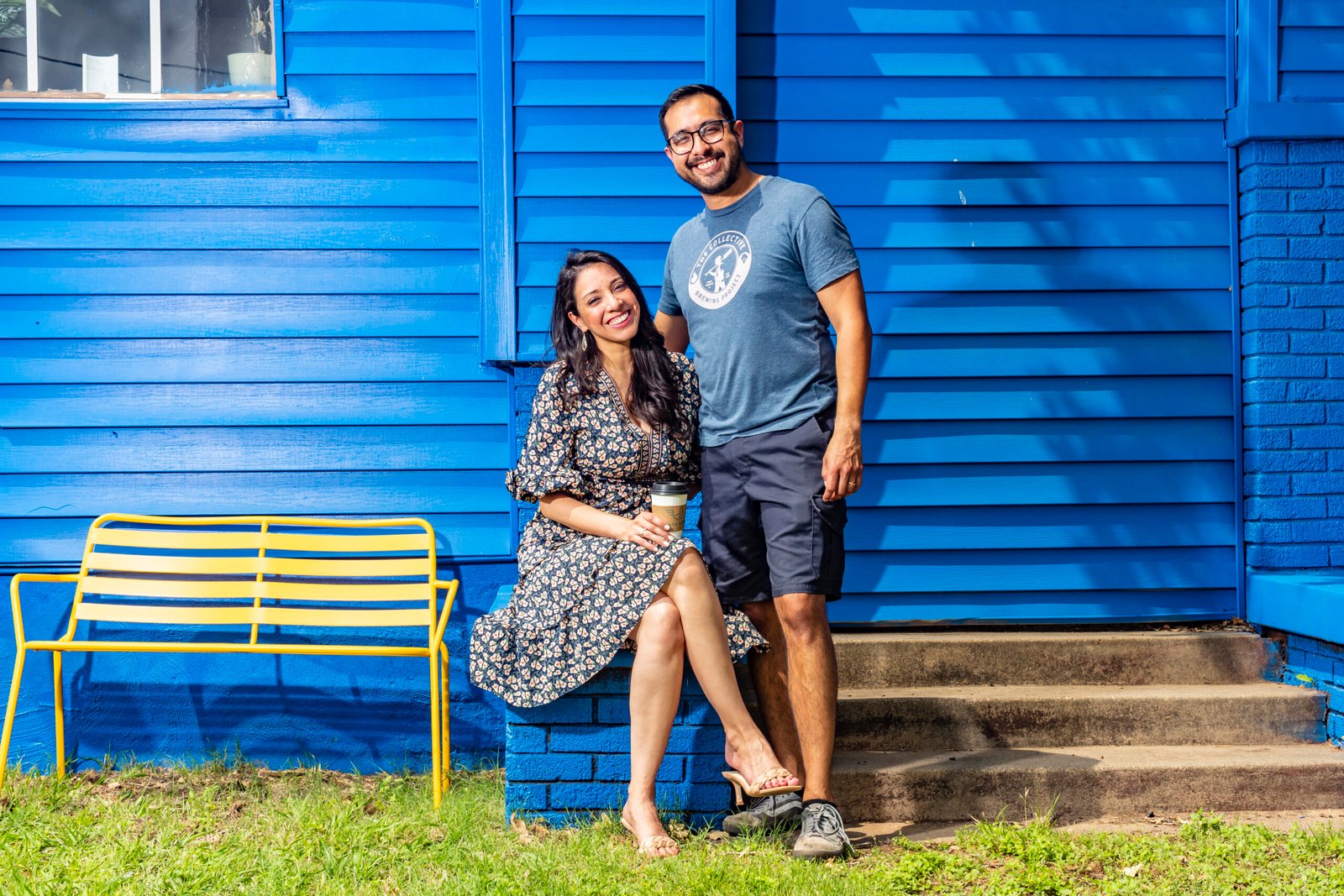 Photo of a man and a woman in front of a blue house.