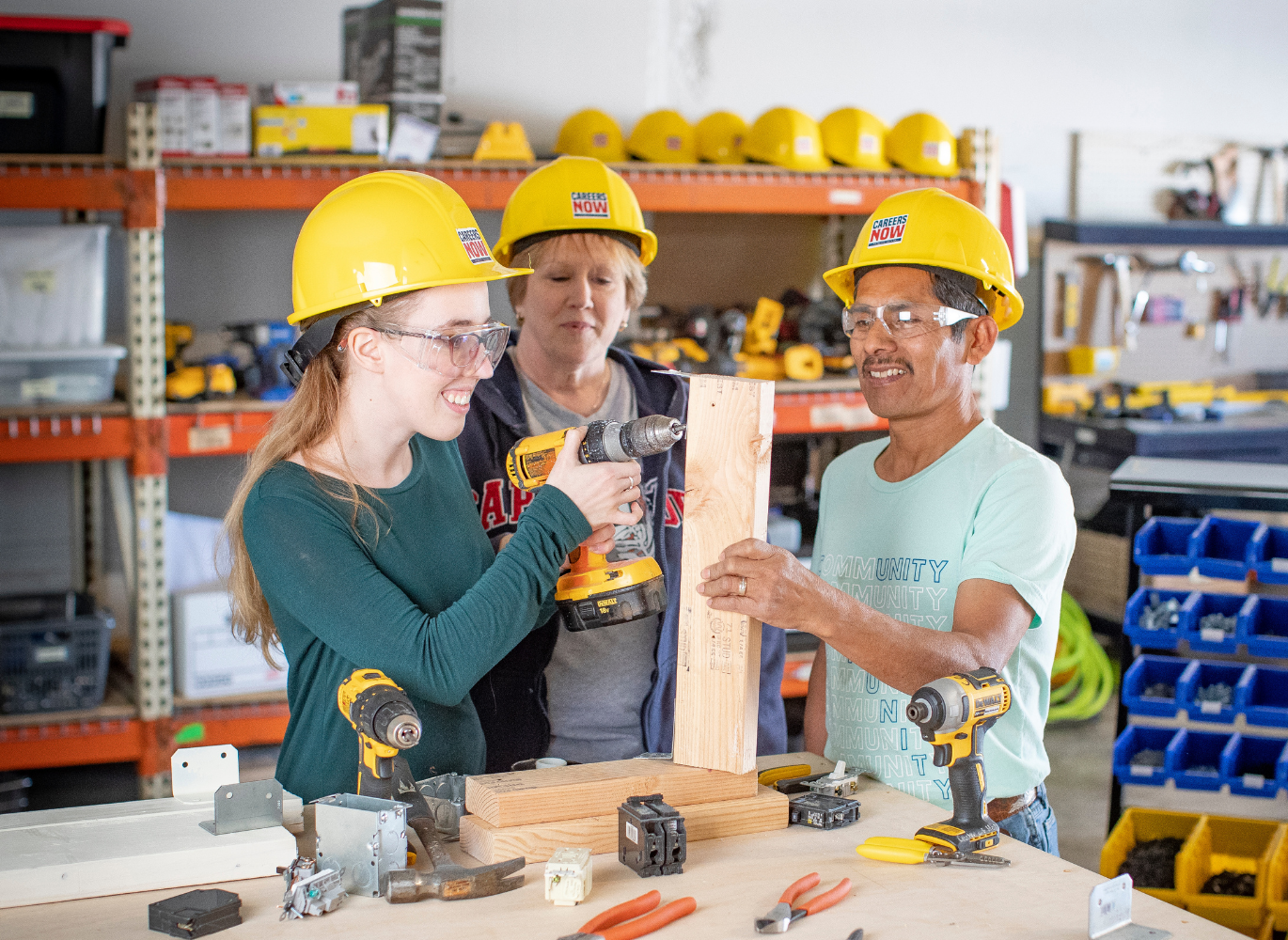 Photo of 3 people with construction hats working on a project